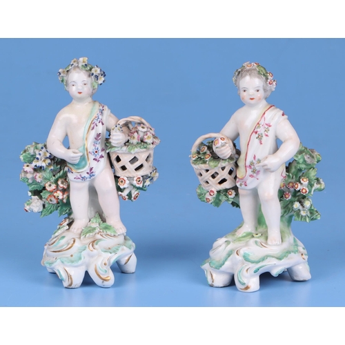 221 - A pair of Chelsea style porcelain figures holding baskets of flowers and having garlands of flowers ... 