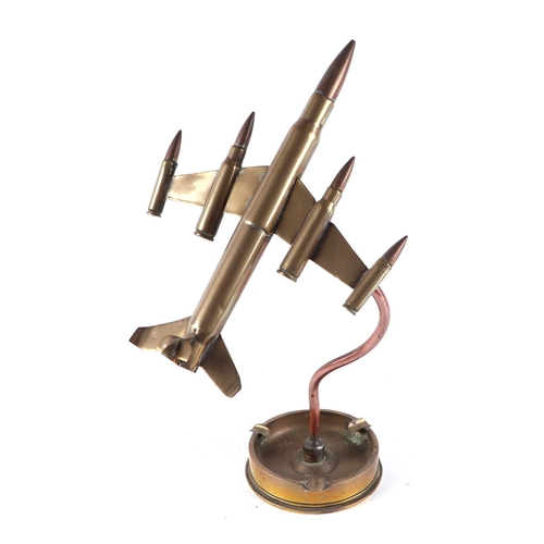 30 - A trench art jet plane, constructed from brass artillery rounds and bullets, mounted on a 1944 dated... 