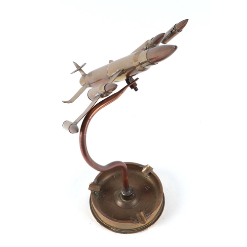 30 - A trench art jet plane, constructed from brass artillery rounds and bullets, mounted on a 1944 dated... 