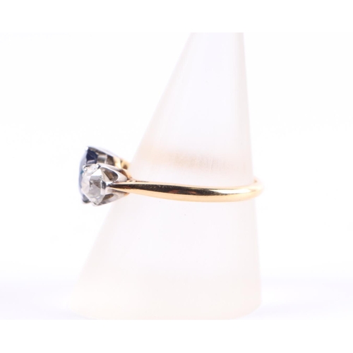 384 - An 18ct gold three-stone diamond and sapphire ring, the diamonds approx 4.8mm diameter, the sapphire... 