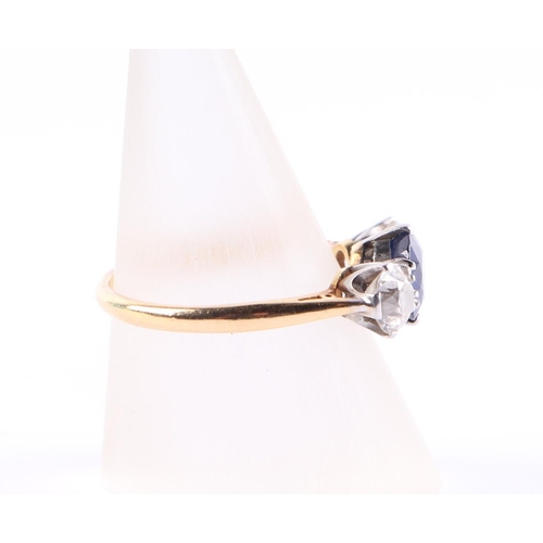 384 - An 18ct gold three-stone diamond and sapphire ring, the diamonds approx 4.8mm diameter, the sapphire... 