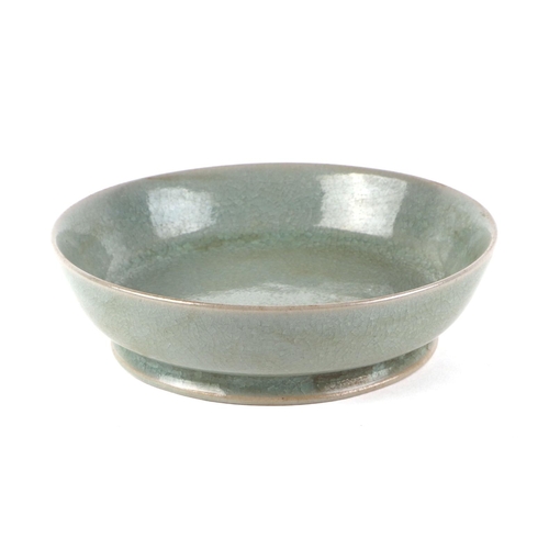 478 - A Chinese crackleware celadon glaze shallow footed bowl, 14.5cms diameter.