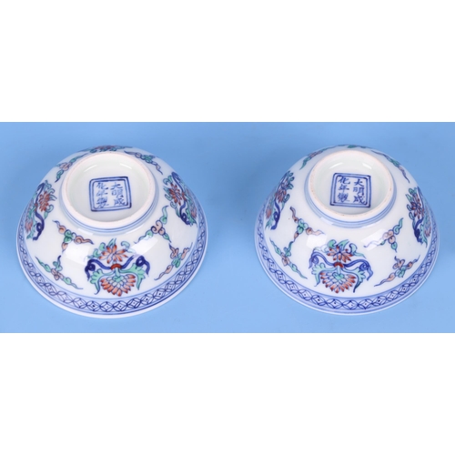 479 - A pair of Chinese Wucai style tea bowls decorated with flowers, six character blue mark to the under... 