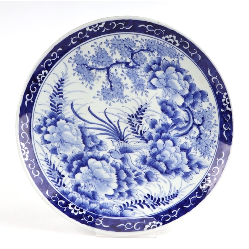 491 - A pair of Japanese blue & white chargers decorated with prunus and birds, each 37cms diameter (2).