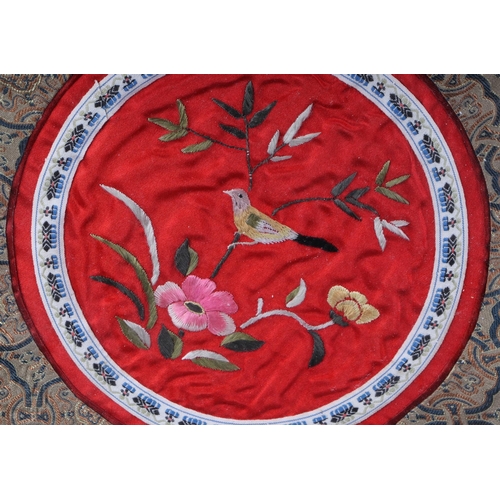 496 - A Chinese embroidered silk work panel, depicting a bird with flowers, 28cm diameter, framed and glaz... 