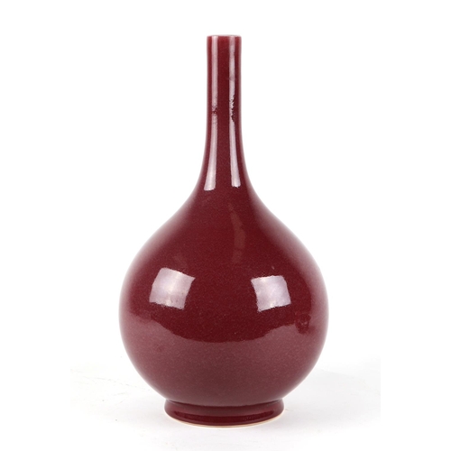 539 - A Chinese ox blood glazed bottle vase on hardwood stand, 34cms high.