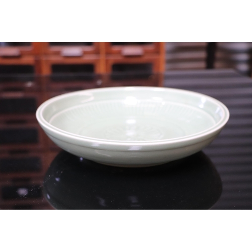 540 - A Chinese celadon glaze shallow dish, with six character blue marks to the underside, 26cm diameter,... 