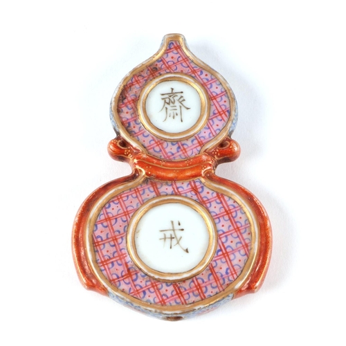 560 - A Chinese famille rose double gourd abstinence pendant, 7cms high; together with a glass globe table... 