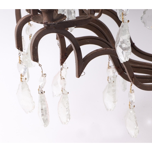 589 - A wrought iron twelve-branch ceiling light with prismatic drops, 73cms high.