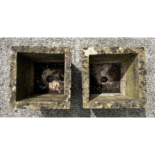 7 - A pair of well weathered reconstituted stone square form planters, 31cms wide (2).