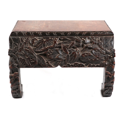 740 - An Oriental kang or low table, the frieze and scroll legs with profusely carved decoration, 104cm wi... 