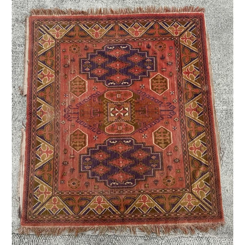 86 - A Persian hand knotted rug with three central guls within multi borders, on a red ground, 162 by 143... 