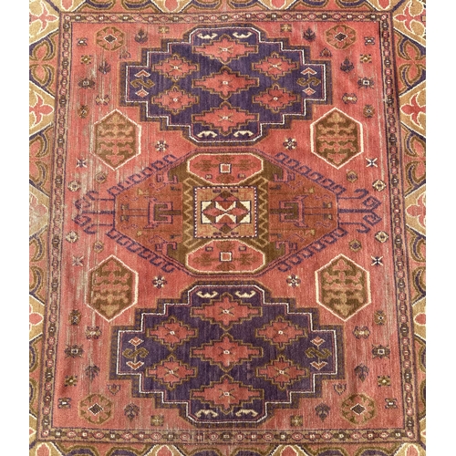 86 - A Persian hand knotted rug with three central guls within multi borders, on a red ground, 162 by 143... 