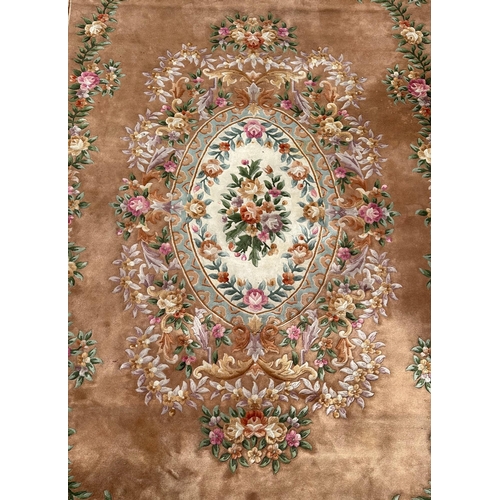 92 - A large Chinese woollen floral design rug on a beige ground, 526 by 336cms.