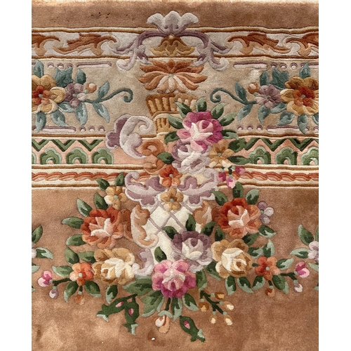 92 - A large Chinese woollen floral design rug on a beige ground, 526 by 336cms.