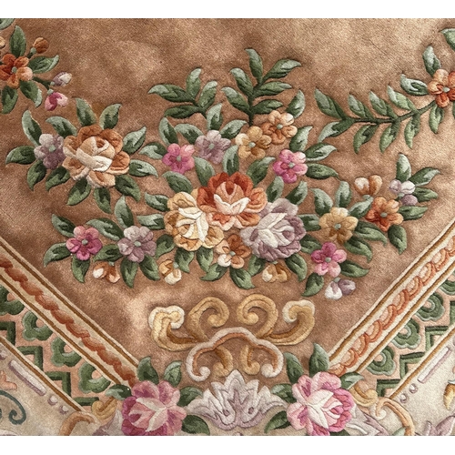 92 - A large Chinese woollen floral design rug on a beige ground, 526 by 336cms.