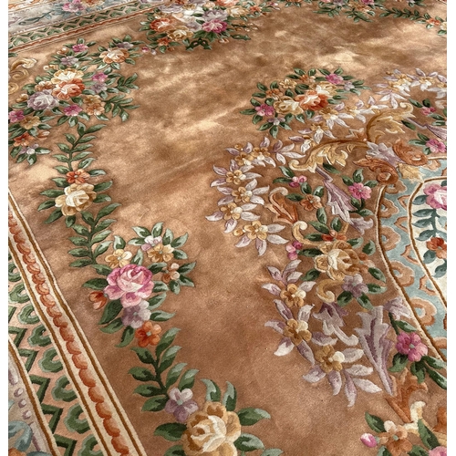 92 - A large Chinese woollen floral design rug on a beige ground, 526 by 336cms.