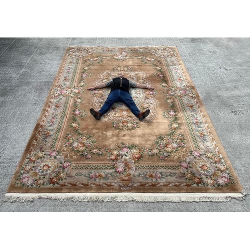 92 - A large Chinese woollen floral design rug on a beige ground, 526 by 336cms.