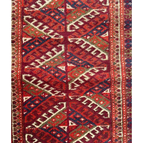 95 - A Persian Balouch hand knotted woollen rug with all over geometric design, on a red ground, 95 by 55... 