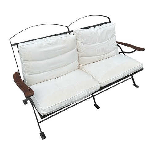 724 - A Modernist strapwork steel sofa of large proportions with feather filled cushions, 185cms wide.