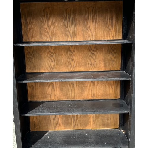 728 - A Chinese ebonised elm bookcase on cupboard in the European taste with a moulded cornice above a pai... 