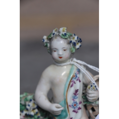 221 - A pair of Chelsea style porcelain figures holding baskets of flowers and having garlands of flowers ... 