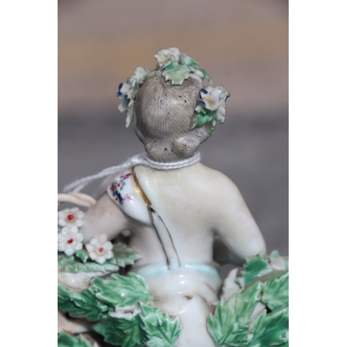 221 - A pair of Chelsea style porcelain figures holding baskets of flowers and having garlands of flowers ... 