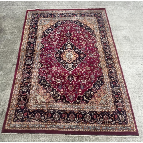 101 - A large Persian hand knotted Isfahan carpet with a central floral medallion and scrolling floral des... 