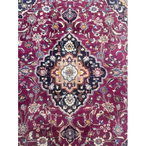 101 - A large Persian hand knotted Isfahan carpet with a central floral medallion and scrolling floral des... 