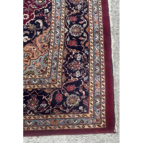 101 - A large Persian hand knotted Isfahan carpet with a central floral medallion and scrolling floral des... 