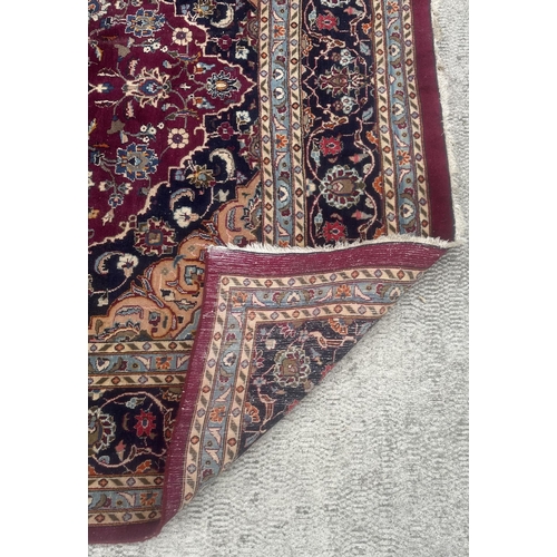 101 - A large Persian hand knotted Isfahan carpet with a central floral medallion and scrolling floral des... 