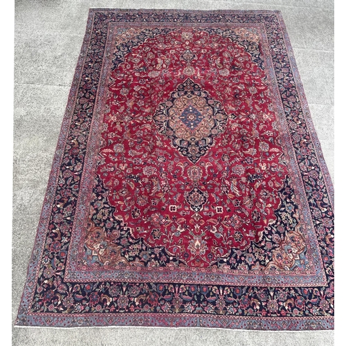 105 - A Persian Meshed carpet with central floral medallion surrounded by stylised floral designs within f... 