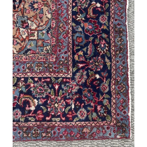 105 - A Persian Meshed carpet with central floral medallion surrounded by stylised floral designs within f... 