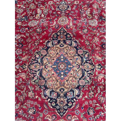 105 - A Persian Meshed carpet with central floral medallion surrounded by stylised floral designs within f... 