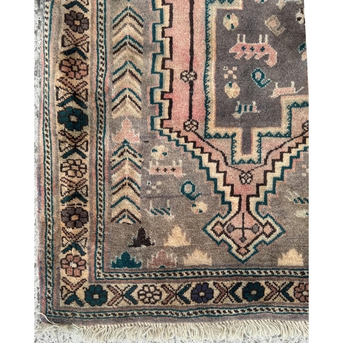 108 - A Persian hand knotted rug with three diamond medallions and stylised animals within a floral border... 