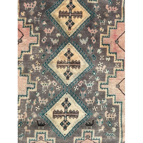 108 - A Persian hand knotted rug with three diamond medallions and stylised animals within a floral border... 