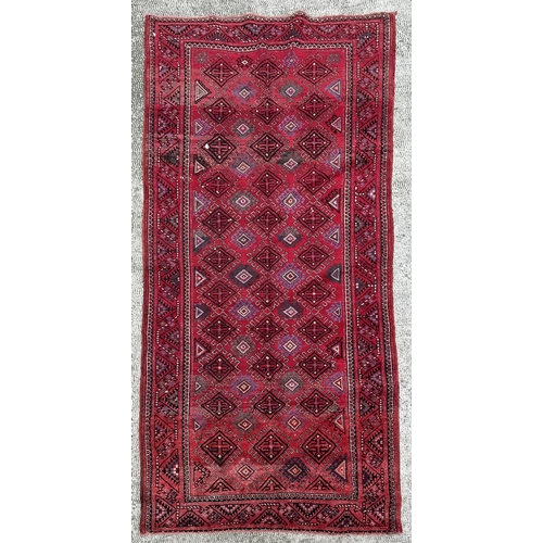 110 - A Persian hand knotted Turkoman runner with repeating guls within guard borders, 290 by 145cms.