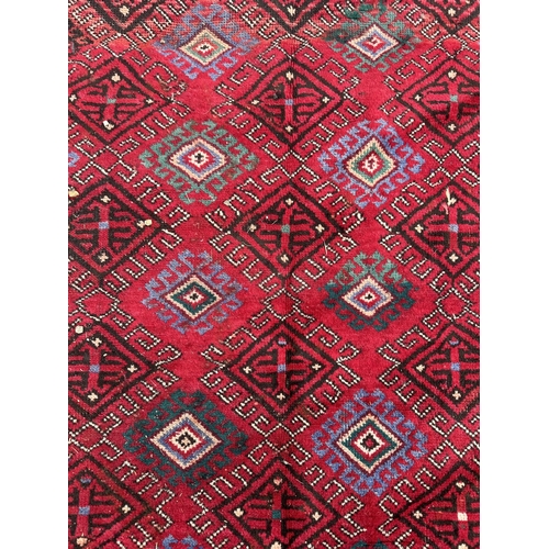 110 - A Persian hand knotted Turkoman runner with repeating guls within guard borders, 290 by 145cms.