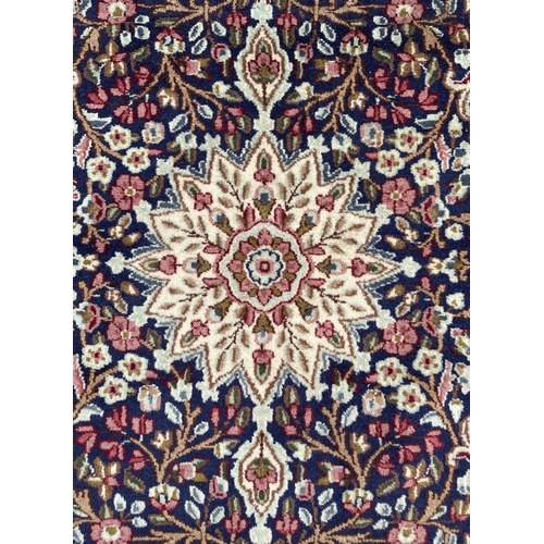 111 - A good quality Persian Kerman rug with central floral medallion within floral borders, on a cream gr... 