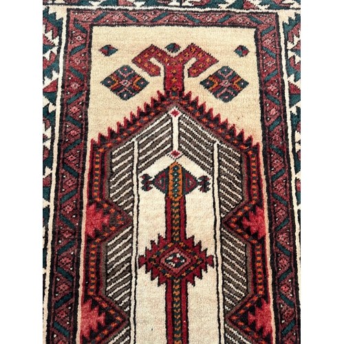 113 - A Persian hand knotted Qashqai runner with two red lozenges within a repeating stylised design, on a... 