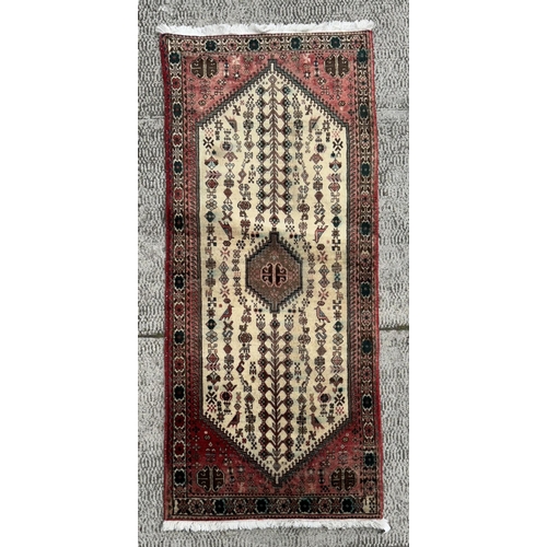 114 - A Persian hand knotted Shiraz runner with central medallion within rows of stylised animals and a fl... 