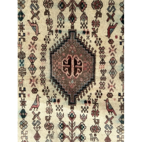 114 - A Persian hand knotted Shiraz runner with central medallion within rows of stylised animals and a fl... 