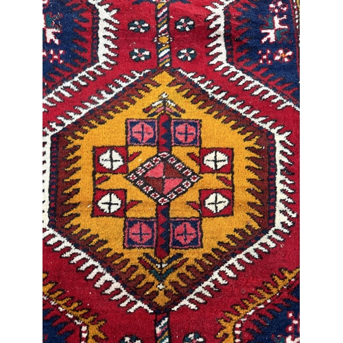 115 - A Persian hand knotted Azari runner with yellow and navy medallions, on a red ground, 410 by 85cms.