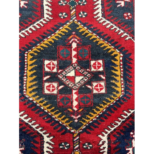 115 - A Persian hand knotted Azari runner with yellow and navy medallions, on a red ground, 410 by 85cms.