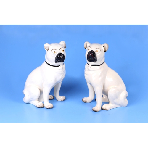 295 - A pair of 19th century Staffordshire pottery seated pug dogs, 27cms high.