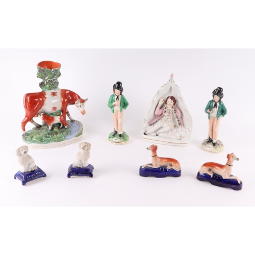 316 - A group of Staffordshire pottery figures to include a cow and calf spill vase; a pair of greyhound p... 