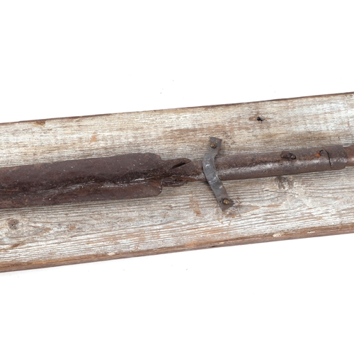 329 - A 19th century African tribal spear head mounted on a wooden plaque with inscription 'North African ... 