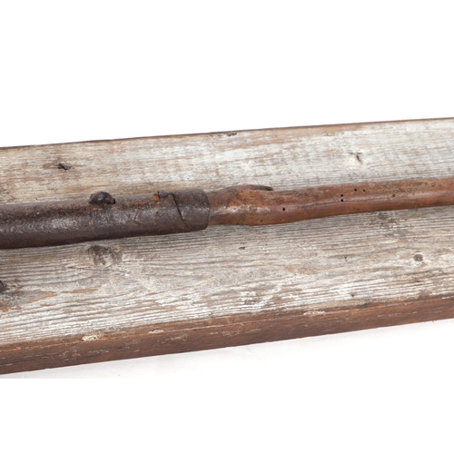 329 - A 19th century African tribal spear head mounted on a wooden plaque with inscription 'North African ... 