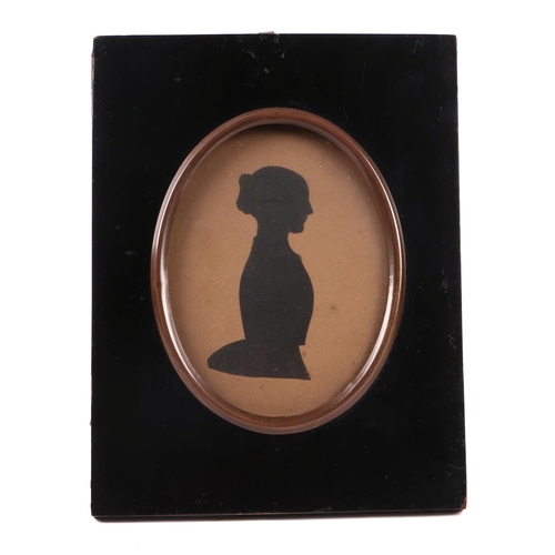 413 - A Victorian oval silhouette depicting a young lady, mounted in a strut frame, 16cms wide.