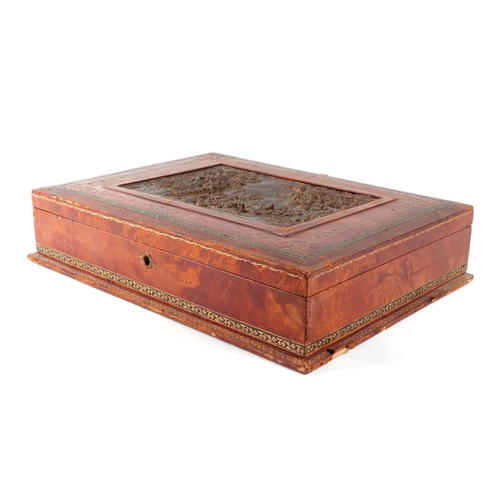 427 - A tooled leather table top box, the lid inset with a hunting scene, with a fitted interior, 42cms wi... 